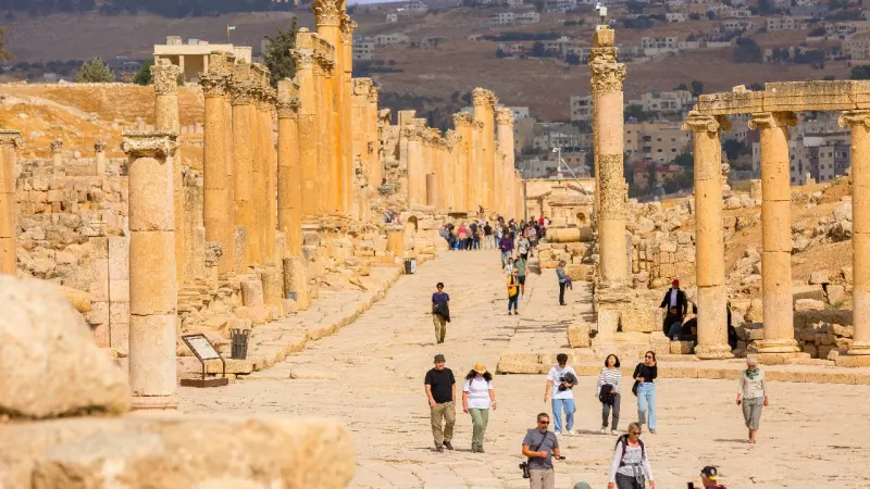 Turistas explorando las ruinas romanas de Jerash durante la Ruta Jordania 8 dias